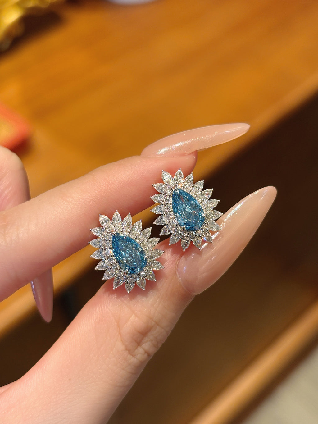 Pear Shaped Blue Diamond Stud Earrings | Halo Floral Setting | Diamond Accent Sunburst Design | 18K White Gold