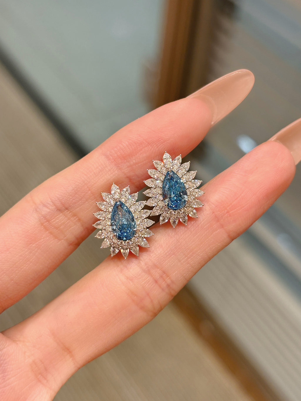 Pear Shaped Blue Diamond Stud Earrings | Halo Floral Setting | Diamond Accent Sunburst Design | 18K White Gold